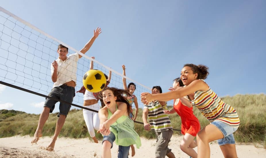 Teens playing volleyball