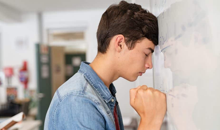 Stressed high school student having difficulty in solving equation