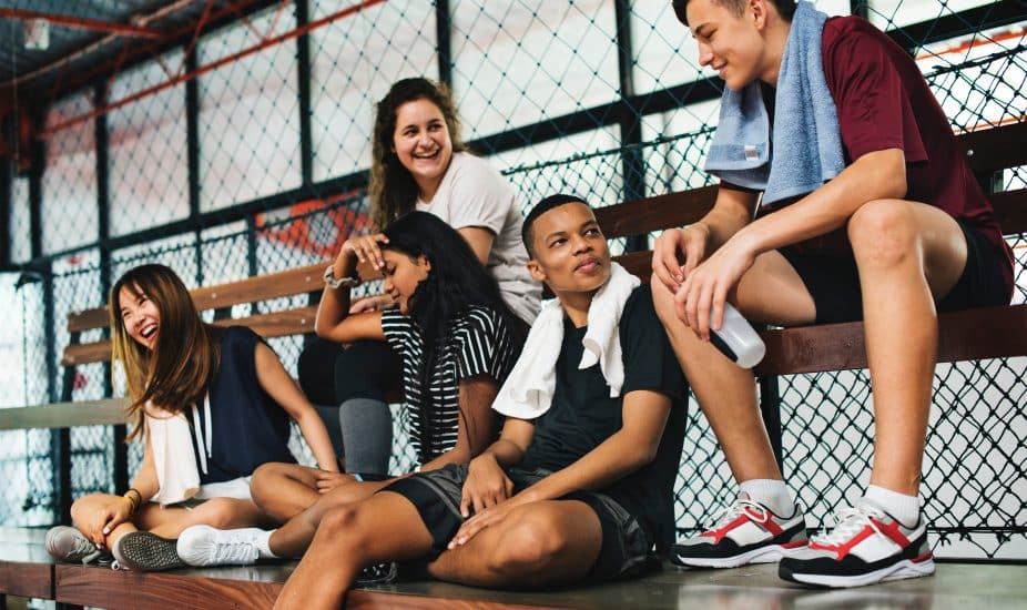 Group of young teenager friends sitting on a bench relaxing