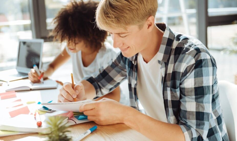 Positive young male writing