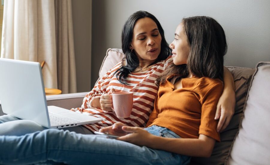 Single mother working from home with preteen daughter around